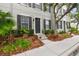 Exterior of gray townhome with black shutters, gray stairs, and green plants at 11541 Fountainhead Dr, Tampa, FL 33626