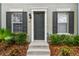 Up close exterior of a gray townhome with black shutters and a well-manicured lawn at 11541 Fountainhead Dr, Tampa, FL 33626