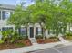 Exterior of gray townhome with black shutters, stone steps, and beautiful landscaping at 11541 Fountainhead Dr, Tampa, FL 33626