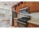 Kitchen features stainless steel appliances, granite countertops, gas range, and warm wood cabinetry at 11541 Fountainhead Dr, Tampa, FL 33626