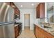 Galley kitchen features stainless steel appliances, gas range, granite countertops, and tile flooring at 11541 Fountainhead Dr, Tampa, FL 33626