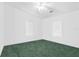 Bright bedroom with two windows, neutral walls, and green carpet flooring at 13015 Elm St, Odessa, FL 33556