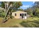 Outdoor shed with a charming exterior, complemented by a well-maintained lawn and surrounding greenery at 13015 Elm St, Odessa, FL 33556