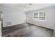 Living room with wood-look floors, ceiling fan, and a white entry door at 15124 Omaha St, Hudson, FL 34667