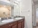 Bathroom featuring a double sink vanity with granite countertops and a tiled walk-in shower at 15306 Broad Brush Dr, Sun City Center, FL 33573