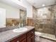 Bathroom with granite countertop vanity, undermount sink and tiled walk-in shower at 15306 Broad Brush Dr, Sun City Center, FL 33573