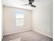 This bedroom features carpet floors, a ceiling fan and a large window for natural light at 15306 Broad Brush Dr, Sun City Center, FL 33573