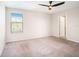 This bedroom features carpet floors, a ceiling fan and a door leading to the bathroom at 15306 Broad Brush Dr, Sun City Center, FL 33573