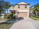 Charming two-story home with an attached two-car garage, mature landscaping and wide driveway at 15306 Broad Brush Dr, Sun City Center, FL 33573