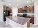 Kitchen features granite countertops, a large island, stainless steel appliances, and tile floors at 15306 Broad Brush Dr, Sun City Center, FL 33573