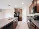 Kitchen with dark cabinetry, granite counters, tile floors, and stainless steel appliances at 15306 Broad Brush Dr, Sun City Center, FL 33573