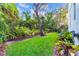 Lush backyard with mature trees, a green lawn, and a serene, landscaped pathway at 15507 Avocetview Ct, Lithia, FL 33547