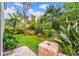 Lush backyard featuring a stone patio, beautiful landscaping, and mature trees providing ample shade at 15507 Avocetview Ct, Lithia, FL 33547