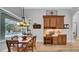 Bright dining room with wood table and chairs, view to pool and custom built-in cabinet at 15507 Avocetview Ct, Lithia, FL 33547