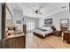 Bright main bedroom with wood furnishings, ceiling fan, and shuttered window at 15507 Avocetview Ct, Lithia, FL 33547