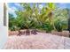 Brick patio featuring wooden chairs and table, surrounded by lush greenery at 15507 Avocetview Ct, Lithia, FL 33547