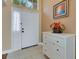 Bright foyer with tiled floor, white wainscoting, and an ornate chest of drawers at 16905 Hawkridge Rd, Lithia, FL 33547