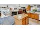 Well-lit kitchen with granite island and adjacent living area perfect for entertaining at 16905 Hawkridge Rd, Lithia, FL 33547