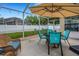 Outdoor seating with umbrella and view of the fenced backyard at 16905 Hawkridge Rd, Lithia, FL 33547