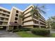 Exterior view of the 1800 Golfview Drive building featuring lush landscaping and covered parking at 1817 Golfview Dr # 1817, Tarpon Springs, FL 34689