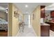 Hallway with white tile floors, glass table, art, and access to other rooms at 1817 Golfview Dr # 1817, Tarpon Springs, FL 34689