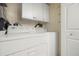 Laundry room with stacked washer and dryer and storage cabinets at 1817 Golfview Dr # 1817, Tarpon Springs, FL 34689