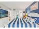 Nautical bedroom offering bed with striped quilt, ensuite bathroom access, and TV at 1930 Laughing Gull Ln # 1225, Clearwater, FL 33762
