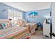 Cozy bedroom with two twin beds, colorful bedding, and a window with shutter blinds at 1930 Laughing Gull Ln # 1225, Clearwater, FL 33762