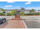 Community clubhouse entrance framed by lush landscaping, brick walkway, and well maintained parking at 1930 Laughing Gull Ln # 1225, Clearwater, FL 33762