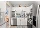 A modern kitchen boasts white cabinets, stainless steel appliances, and a charming view into the next room at 1930 Laughing Gull Ln # 1225, Clearwater, FL 33762