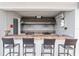Outdoor kitchen equipped with dual electric cooktops, tile counter, stainless-steel sink, and bar stool seating at 1930 Laughing Gull Ln # 1225, Clearwater, FL 33762