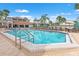 Sparkling community pool with lounge chairs and ample seating and a clear blue sky in the background at 1930 Laughing Gull Ln # 1225, Clearwater, FL 33762