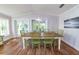 Bright dining room with a large wooden table and views of the outdoor area at 216 Pine Ave # R, Anna Maria, FL 34216