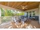 Inviting covered patio with comfortable seating, ceiling fan, and natural wood ceiling at 216 Pine Ave # R, Anna Maria, FL 34216