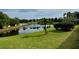 Serene backyard featuring a tranquil pond, lush greenery and mature palm trees at 225 Country Club Dr # A207, Largo, FL 33771