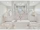 Luxurious bathroom with a soaking tub, dual vanities, and a walk-in shower with marble tile surround at 2402 W Parkland Blvd, Tampa, FL 33609