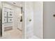 Bright bathroom featuring white-patterned tiles, brass hardware, and a view into the vanity area with elegant details at 2402 W Parkland Blvd, Tampa, FL 33609