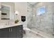 Modern bathroom featuring a sleek vanity, toilet, and a glass-enclosed shower with elegant marble tiling and window at 2402 W Parkland Blvd, Tampa, FL 33609