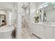 Bright bathroom featuring marble shower, soaking tub, vanity, and stylish lighting fixtures at 2402 W Parkland Blvd, Tampa, FL 33609