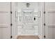 Elegant bathroom with marble floors, a luxurious soaking tub, a rain shower, and white cabinets at 2402 W Parkland Blvd, Tampa, FL 33609