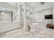 Beautiful primary bathroom features marble floors, a soaking tub, rain shower, double vanity and natural light at 2402 W Parkland Blvd, Tampa, FL 33609