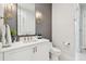 Elegant bathroom with a white vanity, grey wallpaper accent, and sleek fixtures, creating a modern and clean aesthetic at 2402 W Parkland Blvd, Tampa, FL 33609