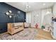 Cozy Bedroom with a crib, soft rug, modern chandelier, and a navy accent wall at 2402 W Parkland Blvd, Tampa, FL 33609