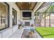 Covered patio area with a built-in fireplace, TV, and comfortable seating at 2402 W Parkland Blvd, Tampa, FL 33609