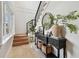 Inviting entryway with a black console table, decorative mirror, and stairs leading to the upper level at 2402 W Parkland Blvd, Tampa, FL 33609