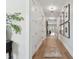 Long hallway with hardwood floors, decorative lighting, and framed art on the walls at 2402 W Parkland Blvd, Tampa, FL 33609
