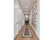 Long hallway featuring hardwood floors, elegant rugs, and a gallery wall with framed photos at 2402 W Parkland Blvd, Tampa, FL 33609