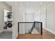 Bright hallway with a modern staircase, hardwood floors, and a laundry area visible through an open doorway at 2402 W Parkland Blvd, Tampa, FL 33609