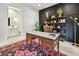 Sophisticated home office with a vintage-style desk, shelving, and a patterned rug, adjacent to a light-filled bathroom at 2402 W Parkland Blvd, Tampa, FL 33609