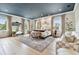 Bright main bedroom featuring hardwood floors, neutral decor, large windows, and cozy seating and large mirror at 2402 W Parkland Blvd, Tampa, FL 33609